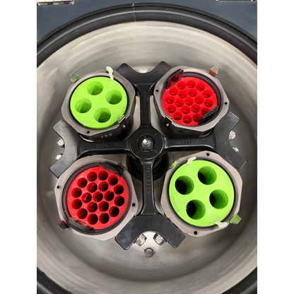 Top-down interior view of the centrifuge chamber showing the four-place swinging bucket rotor with two green and two red tube adapters.