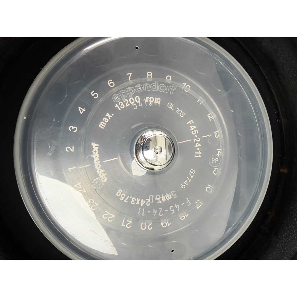 Close-up overhead view of the 24-position Eppendorf F-45-24-11 rotor and plastic lid installed inside the centrifuge chamber.