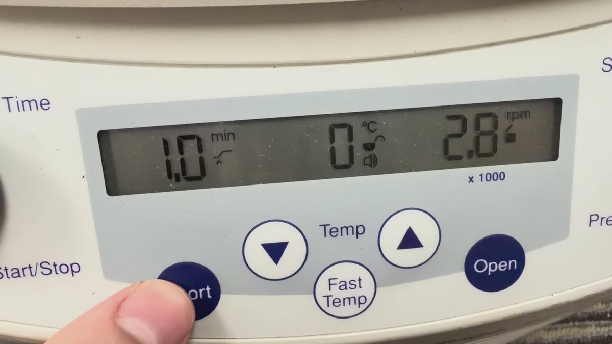 Video showing a close-up of the Eppendorf 5415 R digital control panel in operation. A finger presses and holds the "Short" spin button, while the LCD screen displays the timer counting up in seconds, a temperature reading of 2°C, and the speed accelerating to 2,800 RPM before decelerating when the button is released.