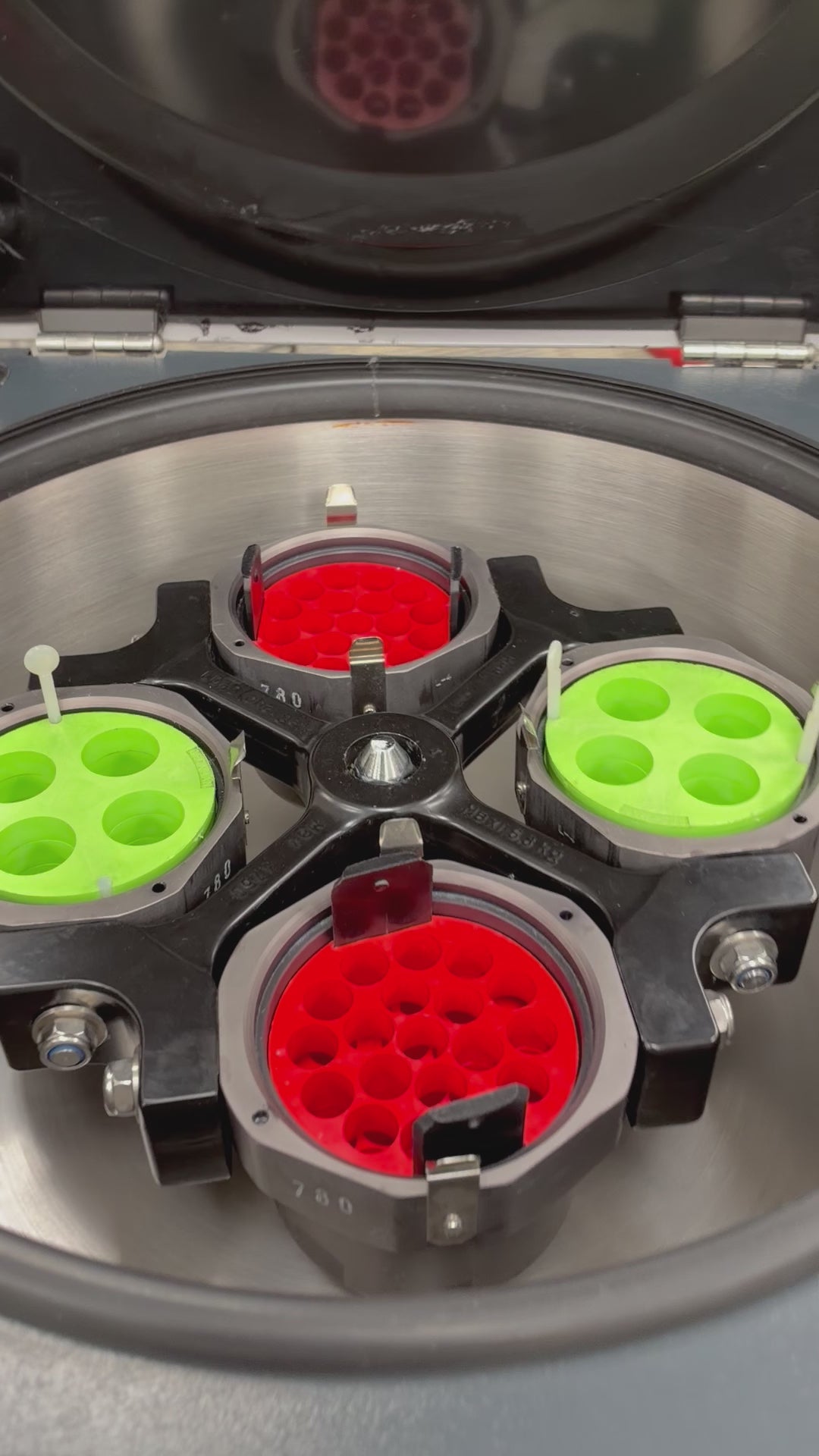 Demonstration video of a Jouan CR4-22 refrigerated centrifuge. A gloved hand rotates the internal 4-place swing bucket rotor to inspect it, closes the heavy lid, presses the start button on the front control panel, and the digital display shows the rotation speed ramping smoothly up to 1500 RPM before being manually stopped.   